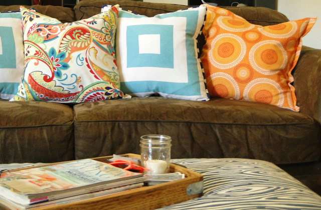 Light and bright pillows help disguise a dark couch