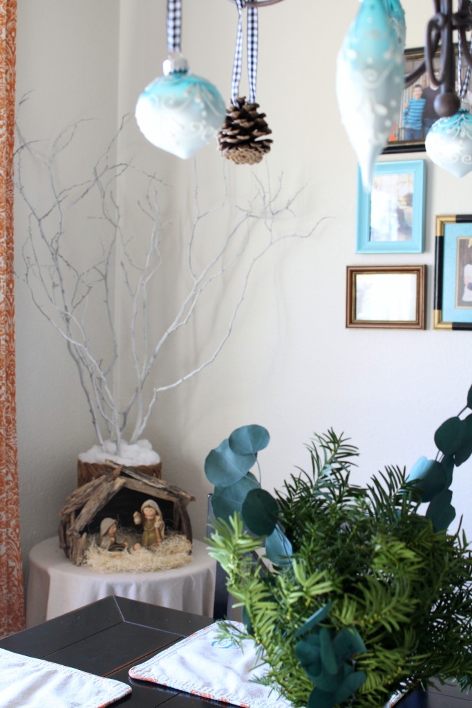 Hang ornaments from the chandelier and add a little greenery