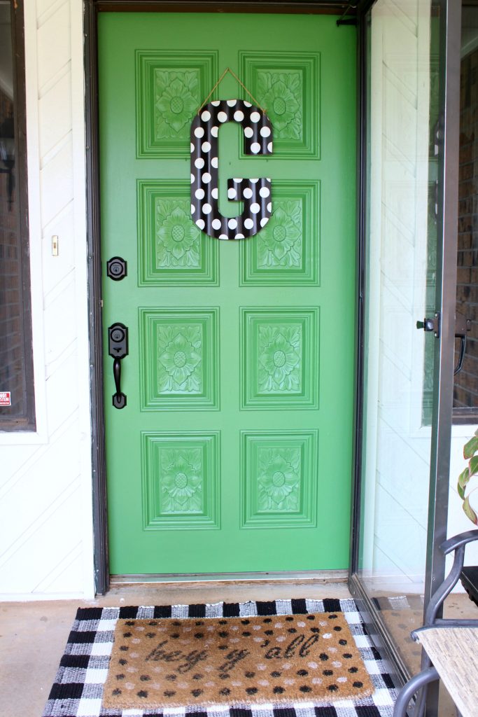 Green painted front door with black and white accessories