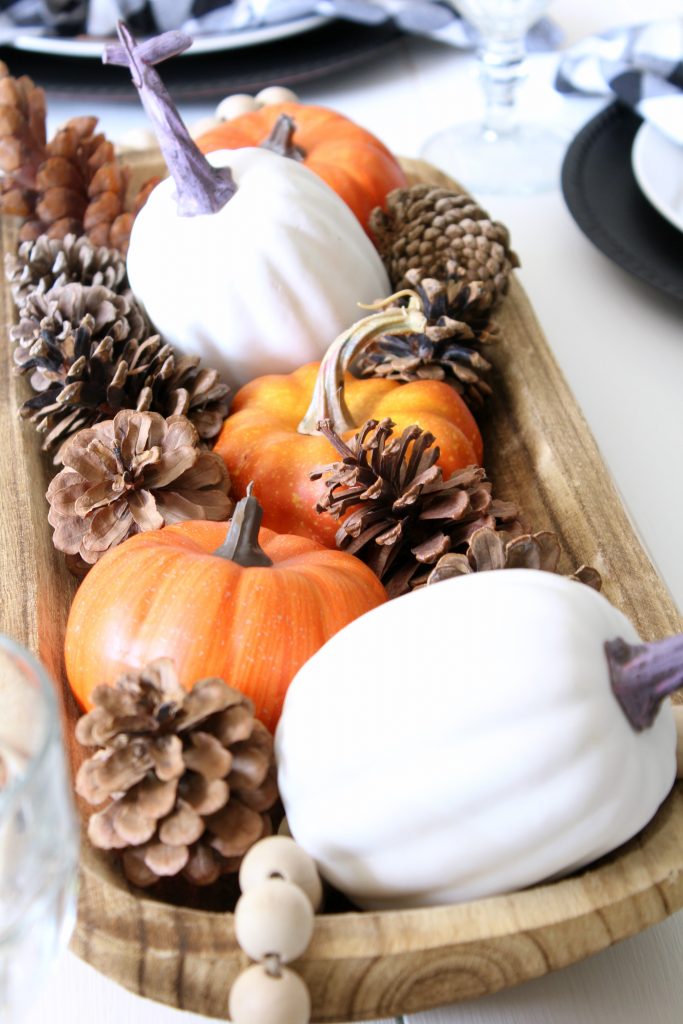 Faux pumpkins mixed with pine cones for fall centerpiece